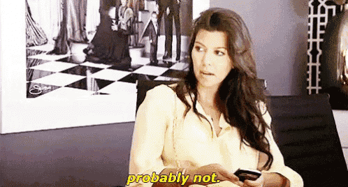a woman is sitting on a couch looking at her cell phone and saying probably not .
