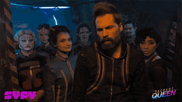 a group of people standing next to each other with the word syfy in the upper right corner