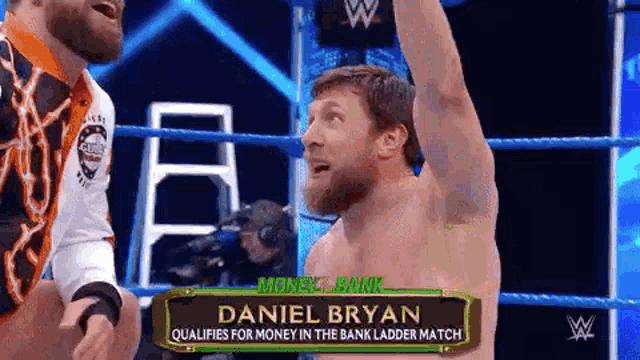 a man is standing in a wrestling ring with his hand in the air .