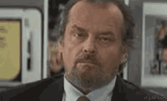 a man in a suit and tie is making a funny face .