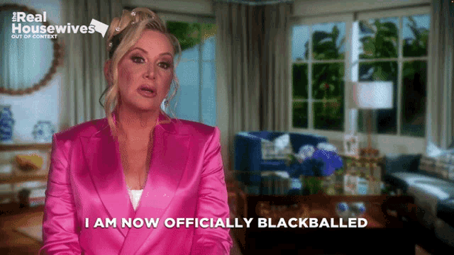 a woman in a pink suit says " i am now officially blackballed " in front of a living room