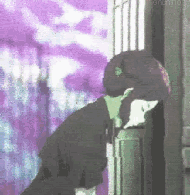 a person is leaning against a door with a purple background