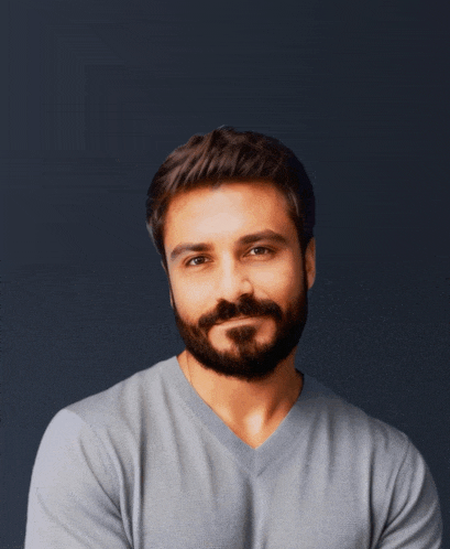 a man with a beard wearing a grey shirt