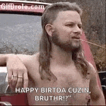 a shirtless man with a mullet and a beard is leaning on a car .