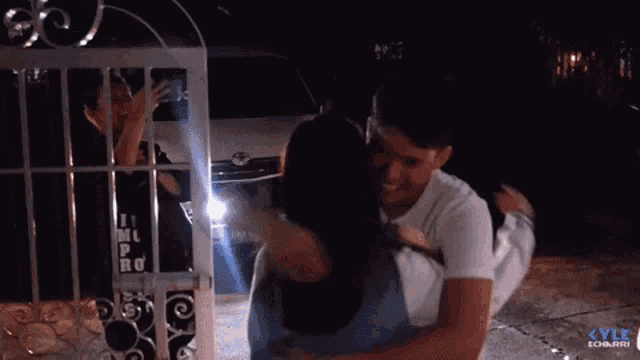 a man is hugging a woman in front of a toyota van