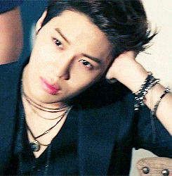 a close up of a man wearing a necklace and bracelet