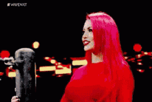 a woman with red hair is clapping her hands in a ring .