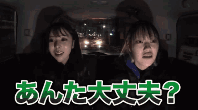 two girls are sitting in the back of a car with chinese writing on the bottom
