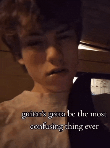 a young boy with a guitar in his mouth and the words " guitar 's gotta be the most confusing thing ever " below him