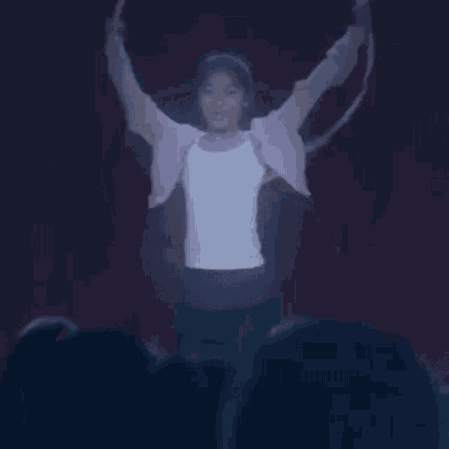 a woman is spinning a hula hoop in front of a crowd of people .