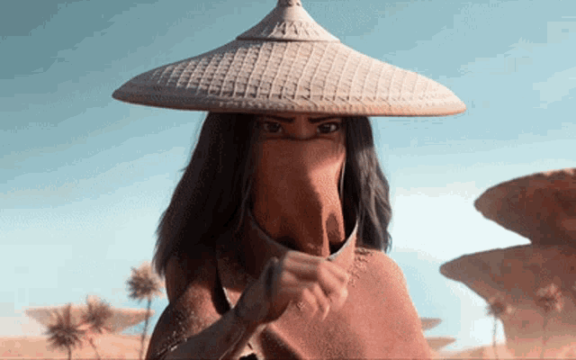 a woman wearing a hat and covering her face with a cloth