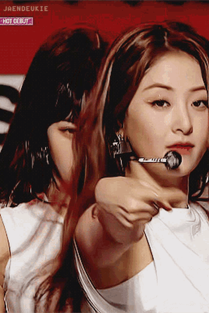 a girl with a microphone in her mouth and the words hot debut on the bottom right