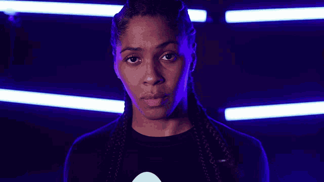 a close up of a woman 's face in front of purple lights