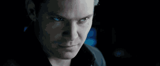 a close up of a man 's face with a blue background