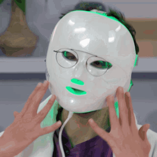 a person is wearing a white mask with green lights on it