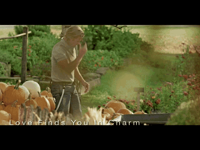 a man standing in front of pumpkins with the words love finds you in charm written below him
