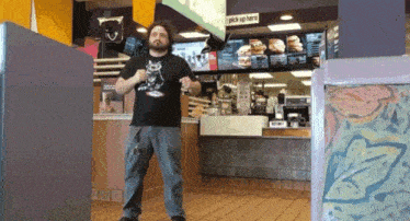 a man in a black shirt stands in front of a mcdonalds counter