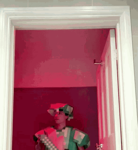 a man dressed as a minecraft character is standing in a doorway