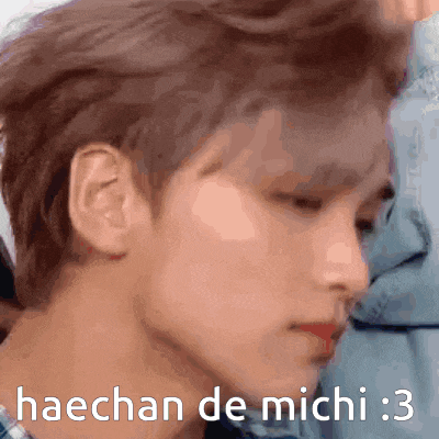 a close up of a person 's face with the words haechan de michi : 3 written on it .