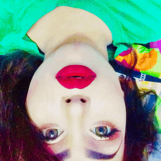 a woman with red lips is upside down on a green shirt