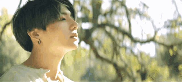 a close up of a person 's face in front of trees