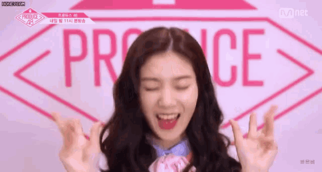 a girl is making a heart shape with her hands in front of a sign that says proce