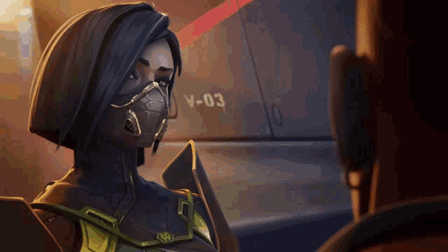 a woman in a mask stands in front of a wall that says v-03