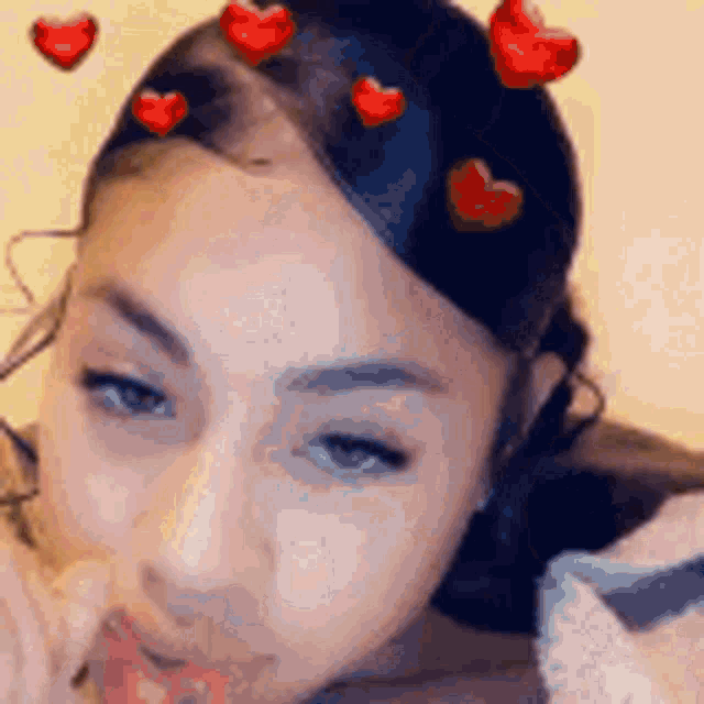 a close up of a woman 's face with hearts on her head .