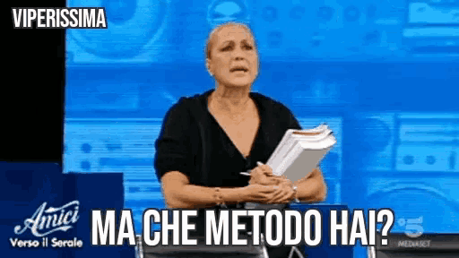 a woman in a black shirt is holding a stack of papers and says " ma che metodo hai "