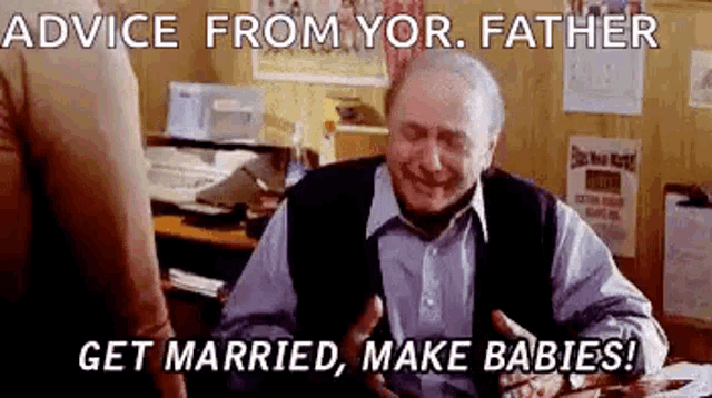 an elderly man is sitting at a desk talking to another man and giving advice from his father .