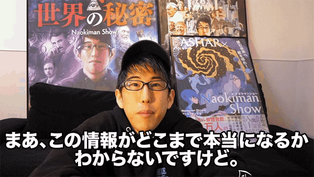 a man is sitting in front of a poster for naokiman show