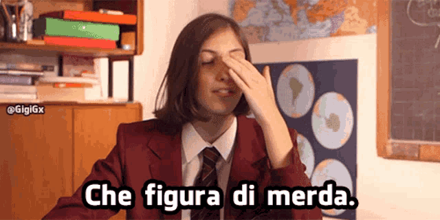 a girl in a red suit and tie wipes her nose with her hand and the words che figura di merda appear below her