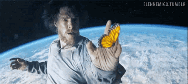 a man is holding a yellow butterfly in his hand in space