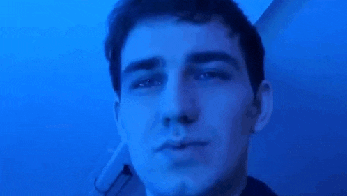a close up of a man 's face in front of a blue background .