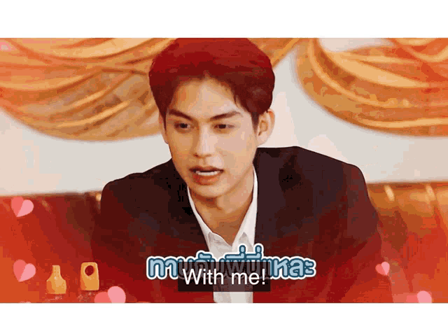 a man in a suit is sitting on a couch and says with me