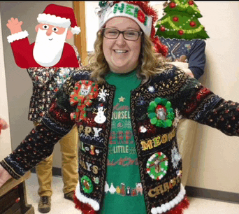 a woman wearing an ugly christmas sweater has a santa hat on