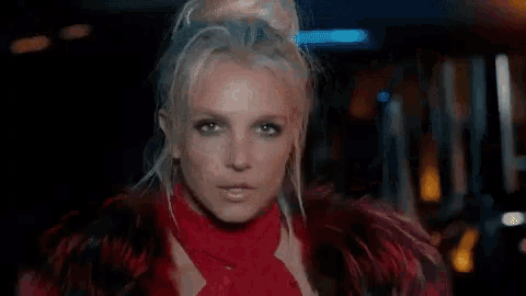 britney spears is wearing a red dress and scarf in a video .