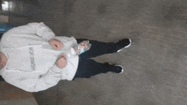 a person wearing a billie eilish hoodie holds a bottle of water