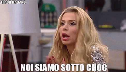 a woman with blonde hair is making a funny face and says noi siamo sotto choc .