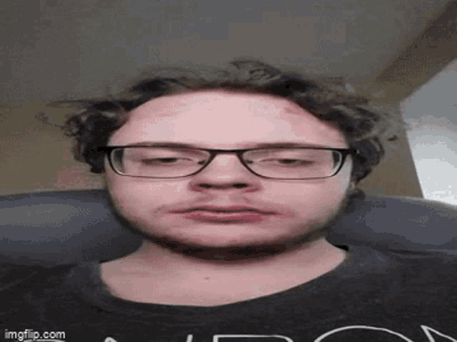 a man with glasses and a beard is wearing a black shirt with the word london on it