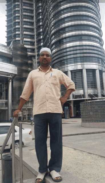 a man standing in front of a tall building with a pen in his pocket