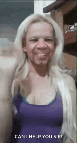 a woman with blonde hair and a purple tank top is smiling and waving .