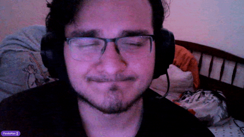 a man wearing glasses and headphones has a purple sticker on his screen that says penisafter