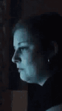 a close up of a woman 's face with a blue light coming from her eyes .