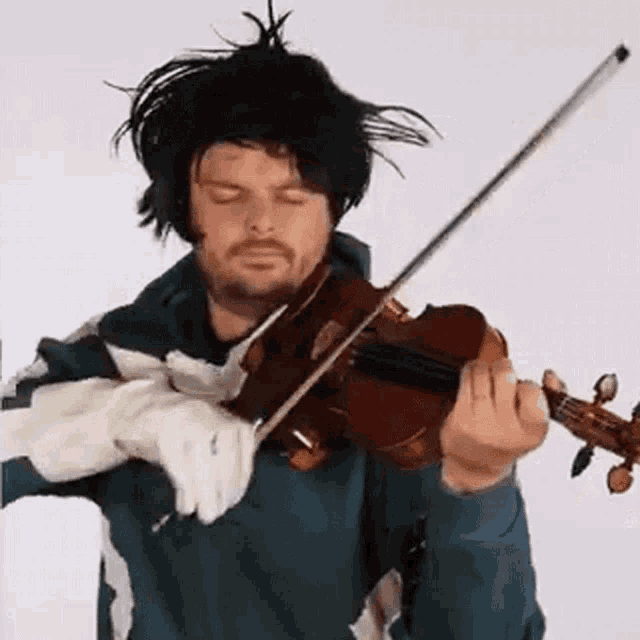 a man in a wig is playing a violin with gloves on his hands .