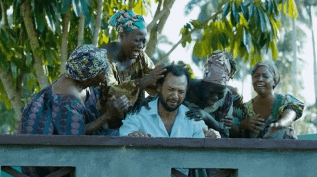 a man with a beard is surrounded by a group of people