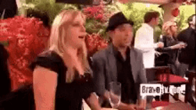 a woman in a black dress is standing next to a man in a black hat .