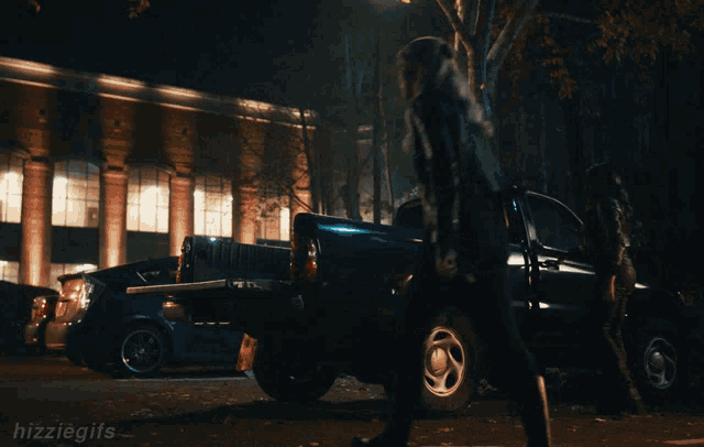 a gif of a woman walking towards a truck that says hizzlegifs on the bottom