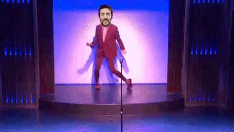 a man in a red suit dancing on a stage
