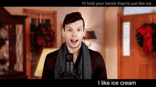 a man with a scarf around his neck is singing into a microphone with the words " i like ice cream " below him